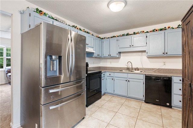 kitchen featuring light tile patterned floors, under cabinet range hood, a textured ceiling, black appliances, and a sink