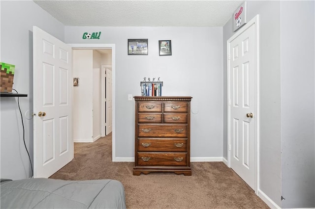 carpeted bedroom with a textured ceiling and baseboards