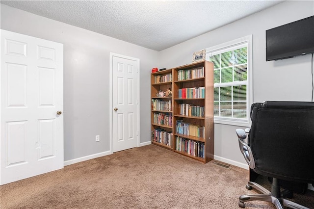 carpeted home office featuring visible vents, baseboards, and a textured ceiling