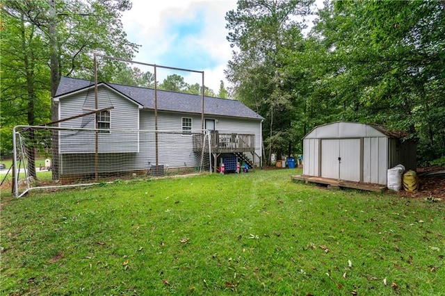 back of house with a storage shed, a yard, a deck, and an outbuilding