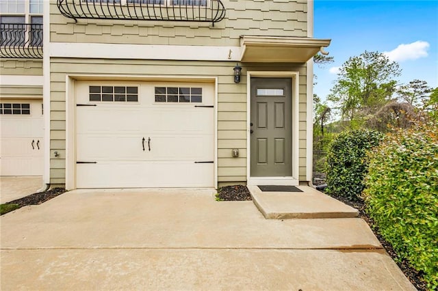 property entrance featuring a balcony and a garage