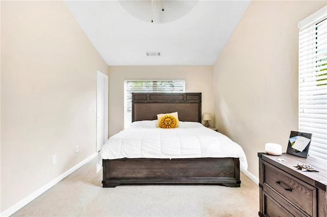 bedroom featuring light colored carpet and vaulted ceiling