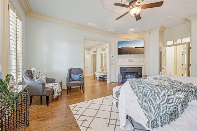 bedroom with ornamental molding, light wood-type flooring, and ceiling fan