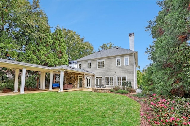 rear view of property with a patio area and a lawn