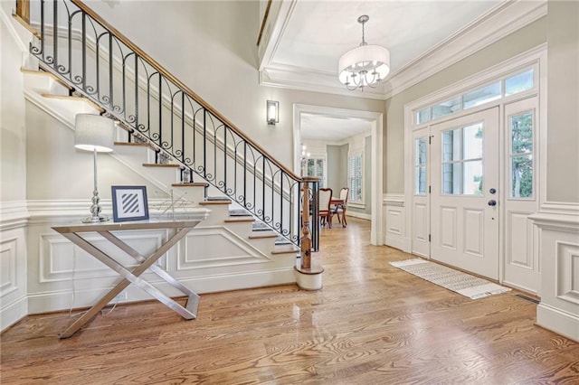 foyer featuring ornamental molding, a notable chandelier, and hardwood / wood-style floors