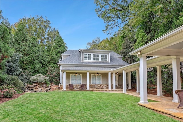 view of front facade with a front yard, a porch, and ceiling fan