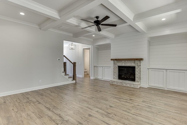 unfurnished living room featuring beamed ceiling, coffered ceiling, and light wood-type flooring