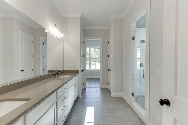 bathroom with crown molding, vanity, tile patterned flooring, and a shower with door