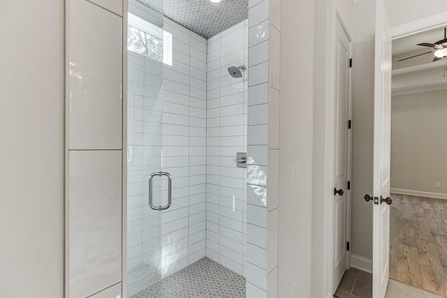 bathroom featuring ceiling fan, a shower with shower door, and hardwood / wood-style floors