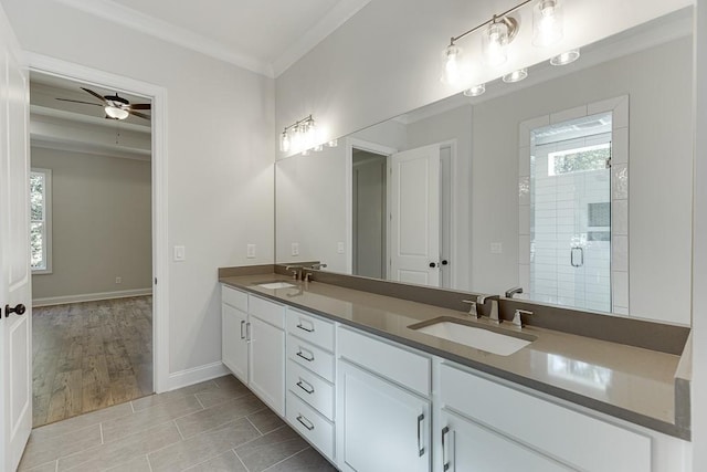 bathroom with a shower with door, vanity, ceiling fan, and crown molding