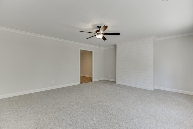 empty room with crown molding, light colored carpet, and ceiling fan