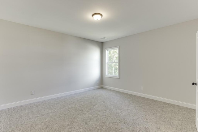 unfurnished room featuring light colored carpet