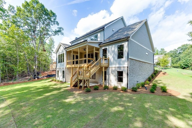 rear view of house featuring a deck, ceiling fan, and a lawn