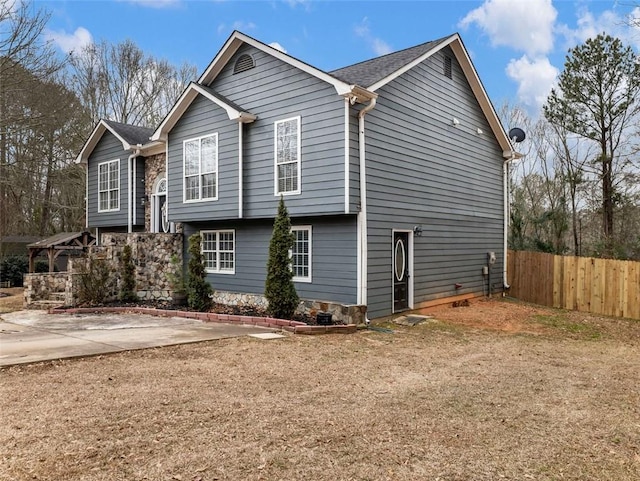 view of home's exterior with a patio and fence