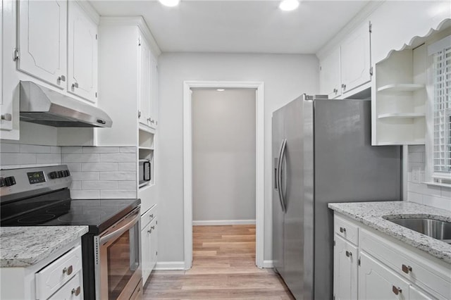 kitchen featuring open shelves, appliances with stainless steel finishes, white cabinetry, light stone countertops, and under cabinet range hood