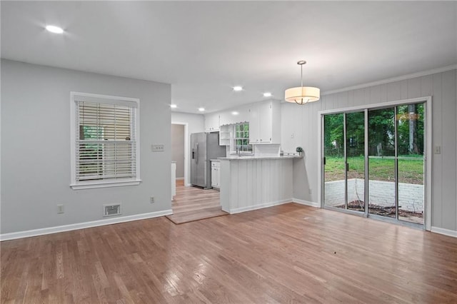 unfurnished living room featuring light wood-type flooring, baseboards, visible vents, and recessed lighting