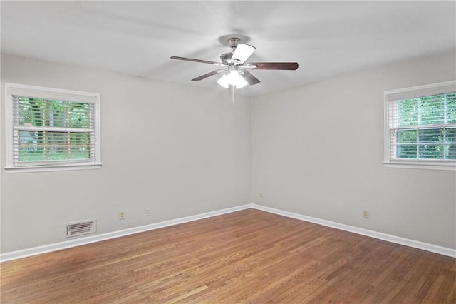 spare room featuring light wood-type flooring, visible vents, and baseboards