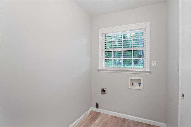 clothes washing area with hookup for a washing machine, hookup for an electric dryer, laundry area, baseboards, and light wood finished floors