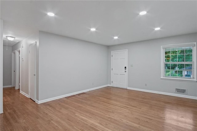 empty room with recessed lighting, visible vents, attic access, light wood-style floors, and baseboards