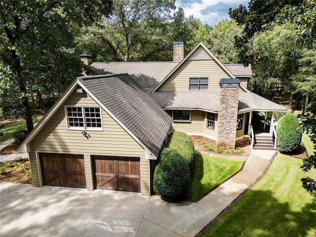 view of front of home with roof with shingles, a chimney, and driveway