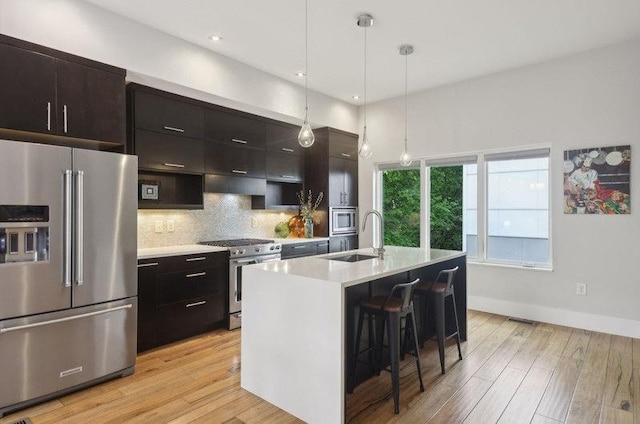 1672 Dekalb Ave NE Unit 2, Atlanta, GA 30307 - kitchen featuring premium appliances, a sink, a kitchen bar, light countertops, and light wood finished floors