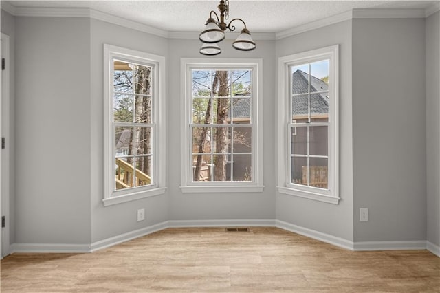 5659 Brookstone Dr NW, Acworth, GA 30101 - unfurnished dining area with a chandelier, light wood-style flooring, baseboards, a textured ceiling, and crown molding