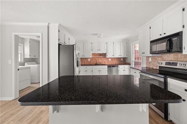 5659 Brookstone Dr NW, Acworth, GA 30101 - kitchen with stainless steel appliances, separate washer and dryer, light wood-style floors, white cabinets, and a textured ceiling