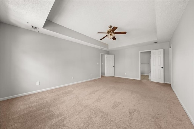 5659 Brookstone Dr NW, Acworth, GA 30101 - unfurnished bedroom with a tray ceiling, light carpet, baseboards, a ceiling fan, and a walk in closet