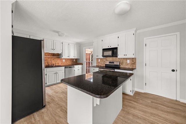 5659 Brookstone Dr NW, Acworth, GA 30101 - kitchen with stainless steel appliances, white cabinetry, ornamental molding, backsplash, and light wood finished floors