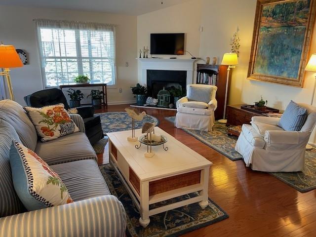 living room with dark hardwood / wood-style flooring and vaulted ceiling