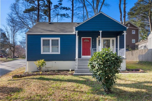 bungalow-style house featuring a front yard, fence, covered porch, and crawl space