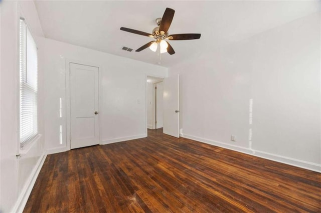 unfurnished bedroom with visible vents, a ceiling fan, baseboards, and wood finished floors