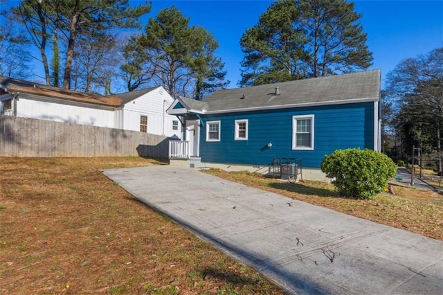 view of front of home featuring concrete driveway, fence, and a front yard