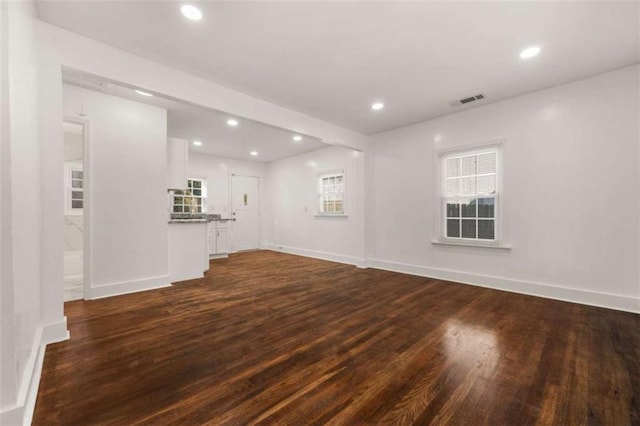 unfurnished living room with dark wood finished floors, recessed lighting, visible vents, and baseboards