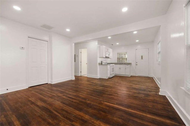 unfurnished living room with recessed lighting, visible vents, baseboards, and dark wood-type flooring