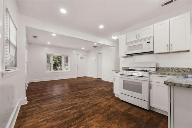 kitchen featuring visible vents, light stone countertops, dark wood-style floors, white cabinets, and white appliances