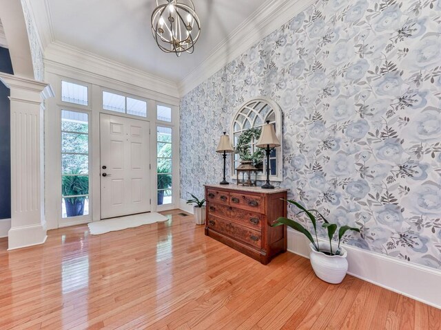 275 Frances Rd, Canton, GA 30114 - foyer entrance with wallpapered walls, light wood-style flooring, a chandelier, decorative columns, and ornamental molding
