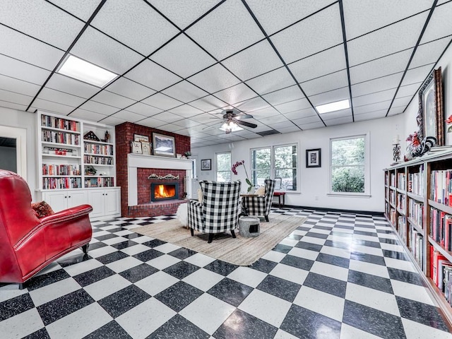 275 Frances Rd, Canton, GA 30114 - living room with a fireplace, a ceiling fan, tile patterned floors, built in shelves, and a drop ceiling