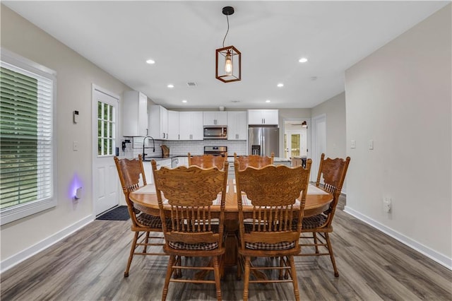 dining area with dark hardwood / wood-style floors and sink