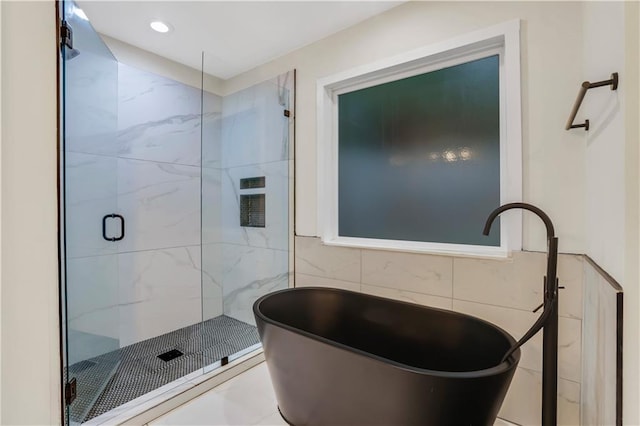 bathroom featuring separate shower and tub and tile walls