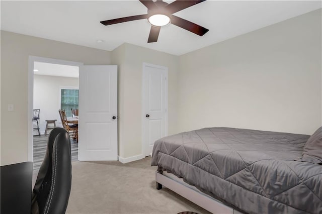 bedroom featuring light carpet and ceiling fan