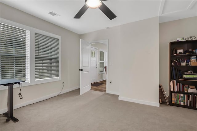 spare room with ceiling fan and light carpet