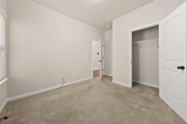 unfurnished bedroom featuring light colored carpet and a closet