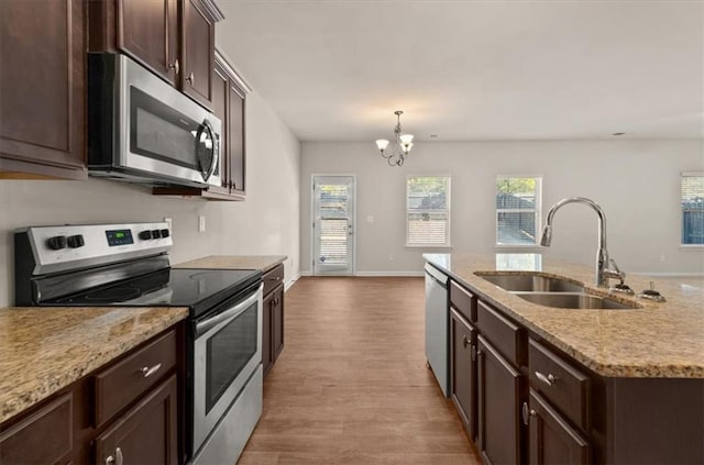 kitchen with sink, light hardwood / wood-style floors, a chandelier, pendant lighting, and appliances with stainless steel finishes