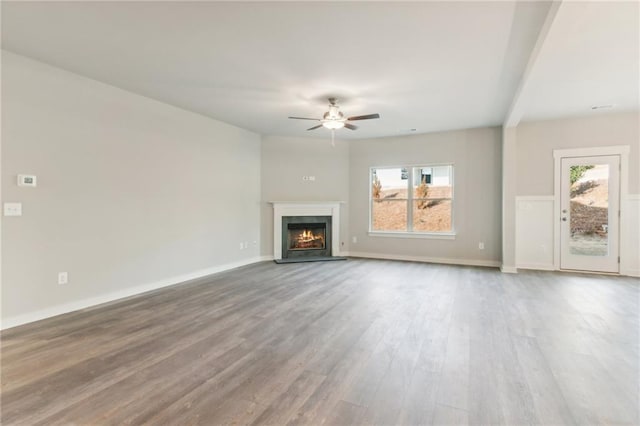 4045 Links Blvd, Jefferson, GA 30549 - unfurnished living room featuring ceiling fan, plenty of natural light, wood finished floors, and a lit fireplace