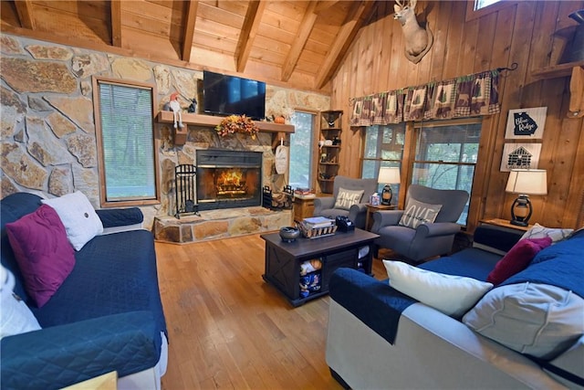 living room with wood ceiling, beam ceiling, a fireplace, wooden walls, and hardwood / wood-style floors