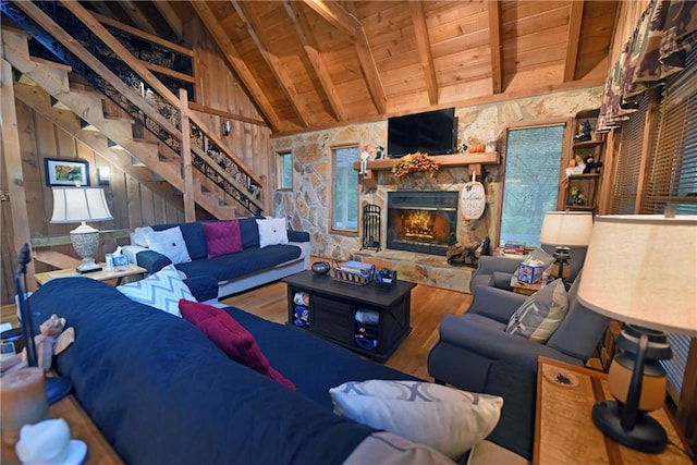 living room featuring lofted ceiling with beams, a fireplace, wood walls, wooden ceiling, and hardwood / wood-style floors