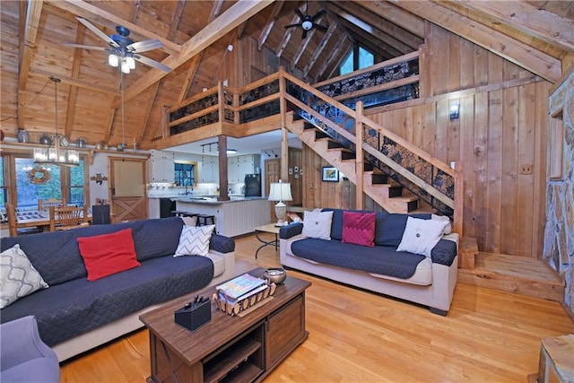 living room featuring beamed ceiling, wood walls, and light hardwood / wood-style floors