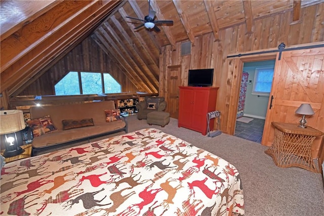 bedroom with a barn door, carpet flooring, lofted ceiling with beams, and ensuite bath