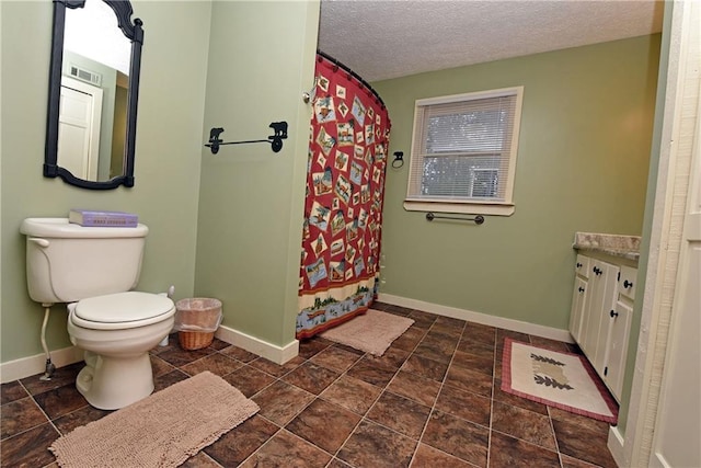 bathroom with a textured ceiling, curtained shower, vanity, and toilet